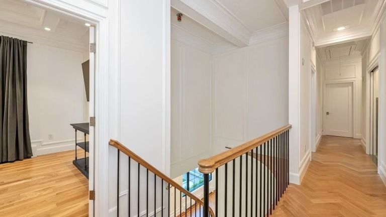 A hallway with stairs leading up to the second floor of a house.