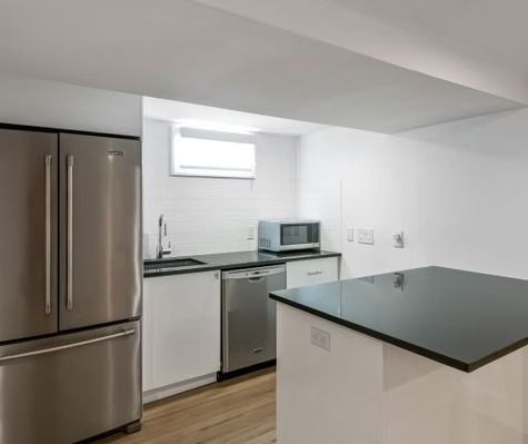 A kitchen with a stainless steel refrigerator , dishwasher , sink and microwave.