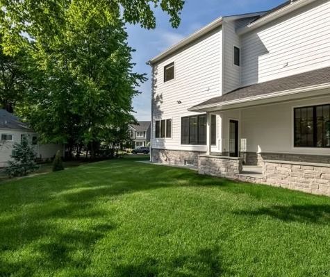 A large white house with a large lawn in front of it.