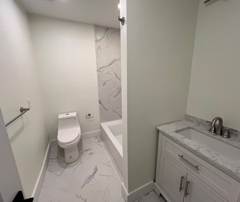 A bathroom with a toilet , sink , and bathtub.