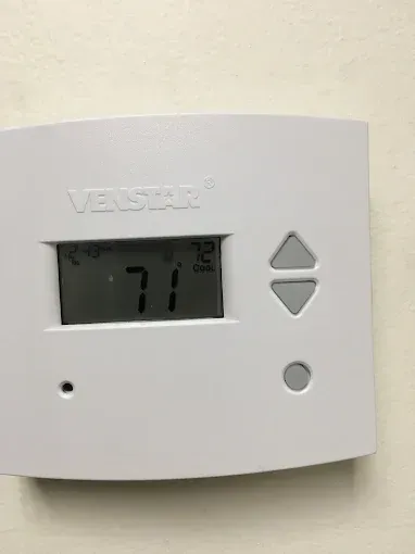 A white Venstar thermostat displays the current temperature of 71 degrees, and the set temperature of 72 degrees.