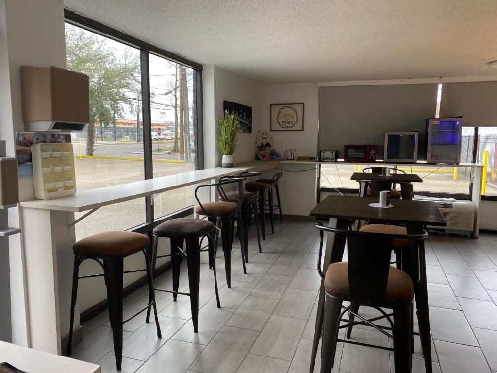 Cafe interior with tables, bar stools, and a large window overlooking the street.