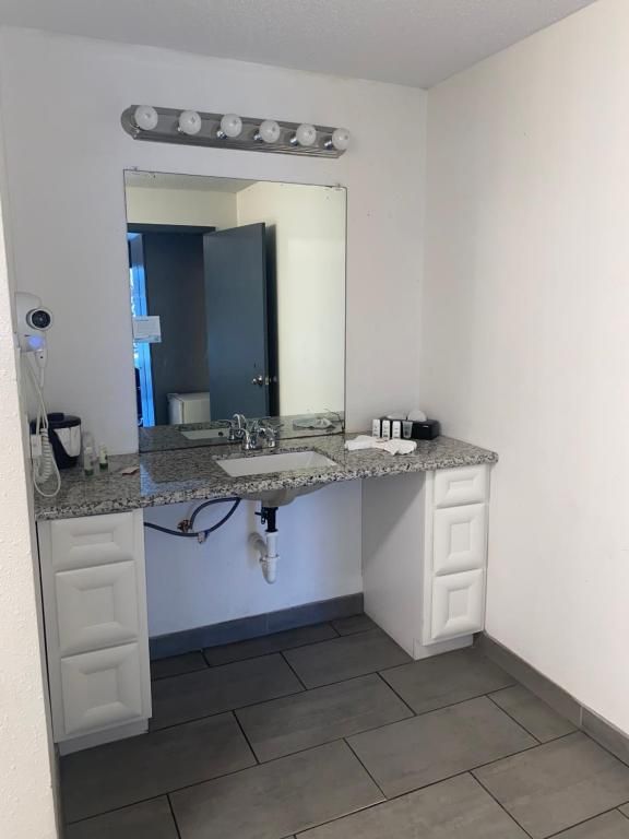 Bathroom with a granite vanity, large mirror, and open space below the sink for wheelchair access.