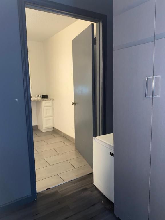 A doorway leading to a small room with a white cabinet. The walls are gray and white.