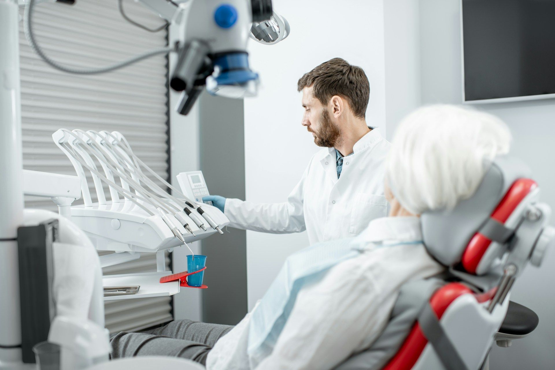 a dentist performing cosmetic dental treatments to a patient.