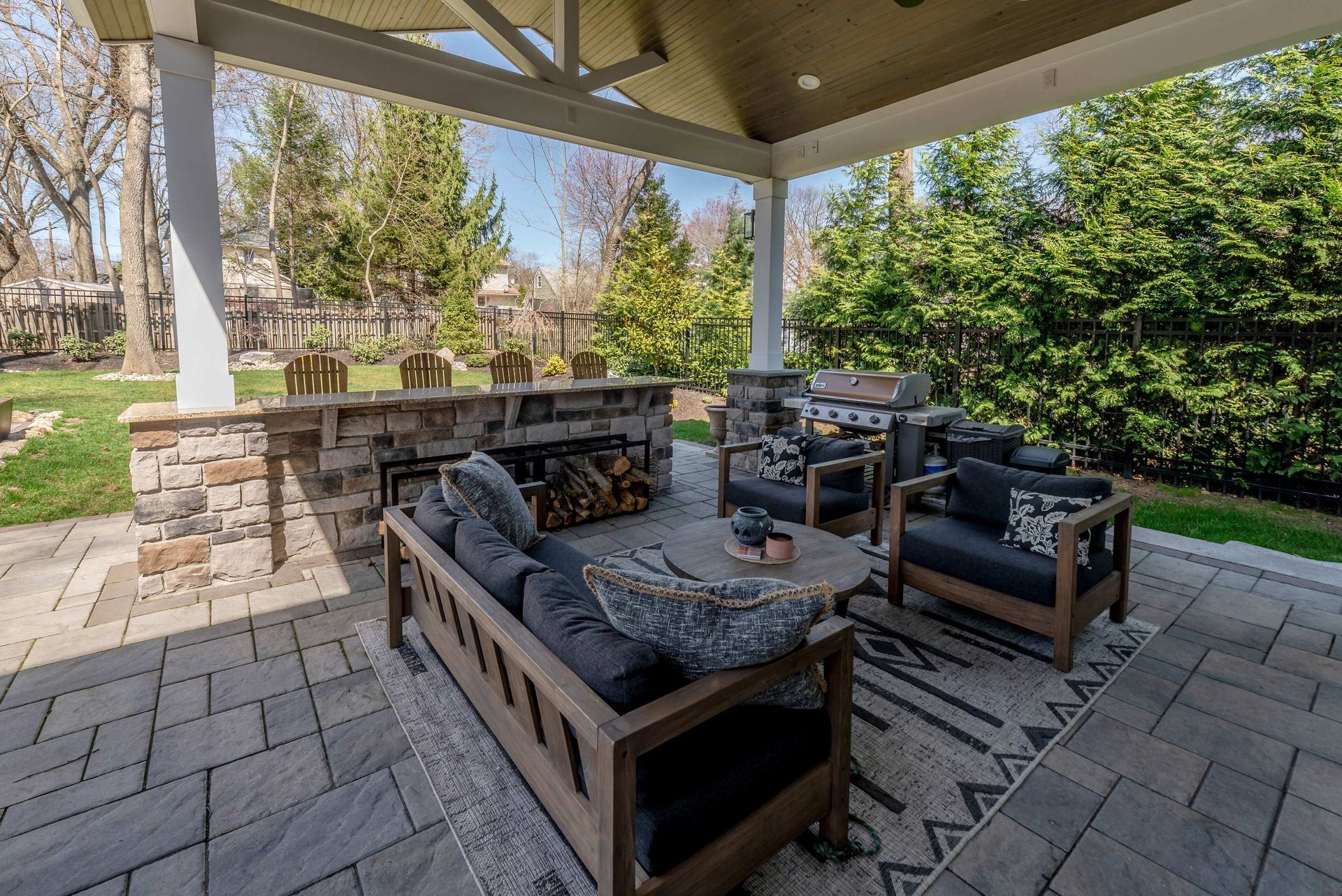 A patio with a couch, chairs, and a fireplace.