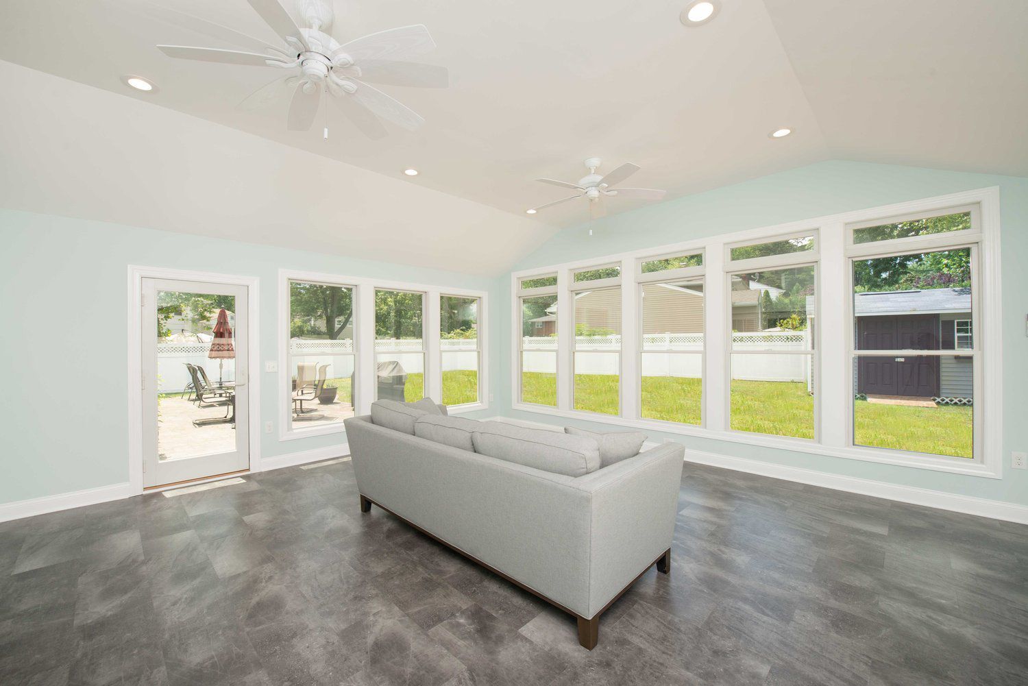 A living room with a couch and a ceiling fan.