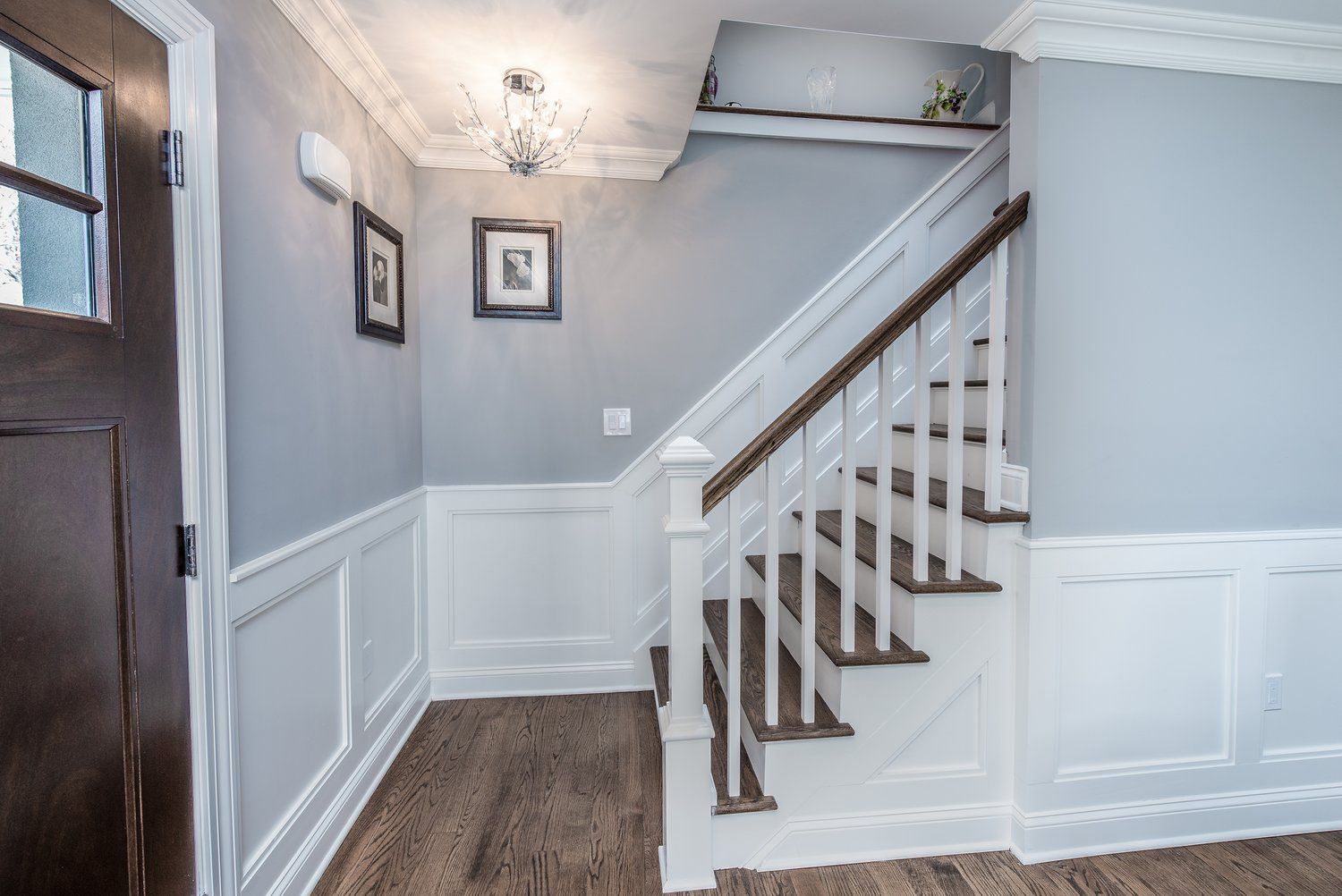 A hallway with stairs leading up to the second floor of a house.