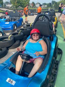 a woman is sitting in a blue go kart 