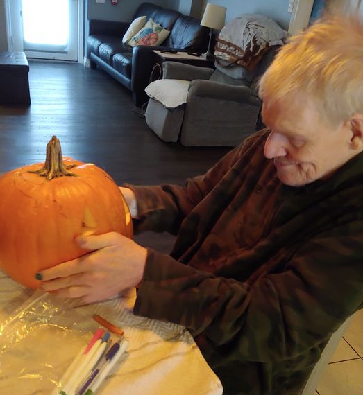 a man is carving a pumpkin in a living room