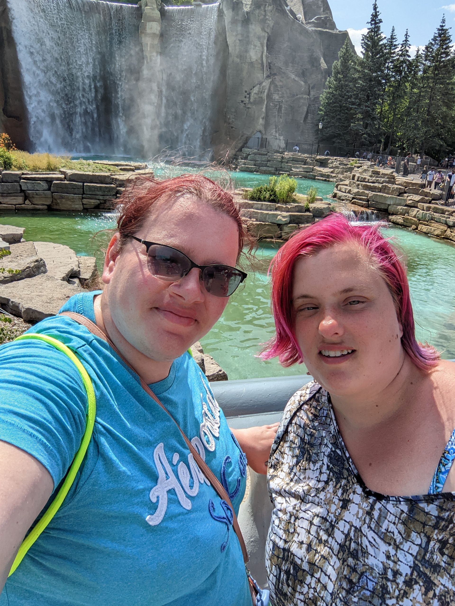 two women are posing for a picture in front of a waterfall at Canadas Wonderland