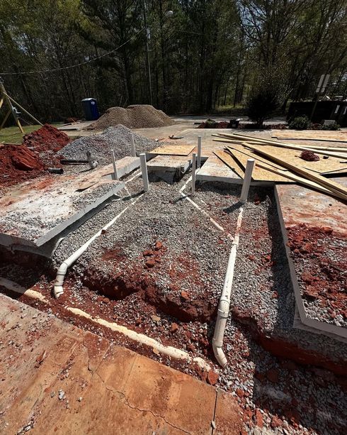 A construction site with a lot of dirt and pipes in the ground.