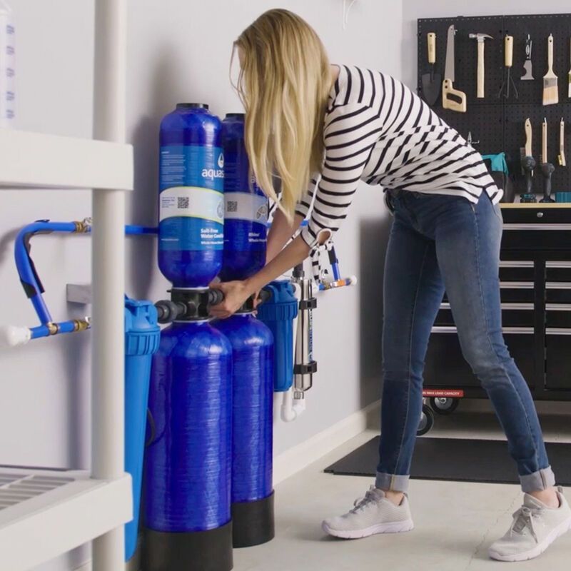 A woman in a striped shirt is working on a water filter
