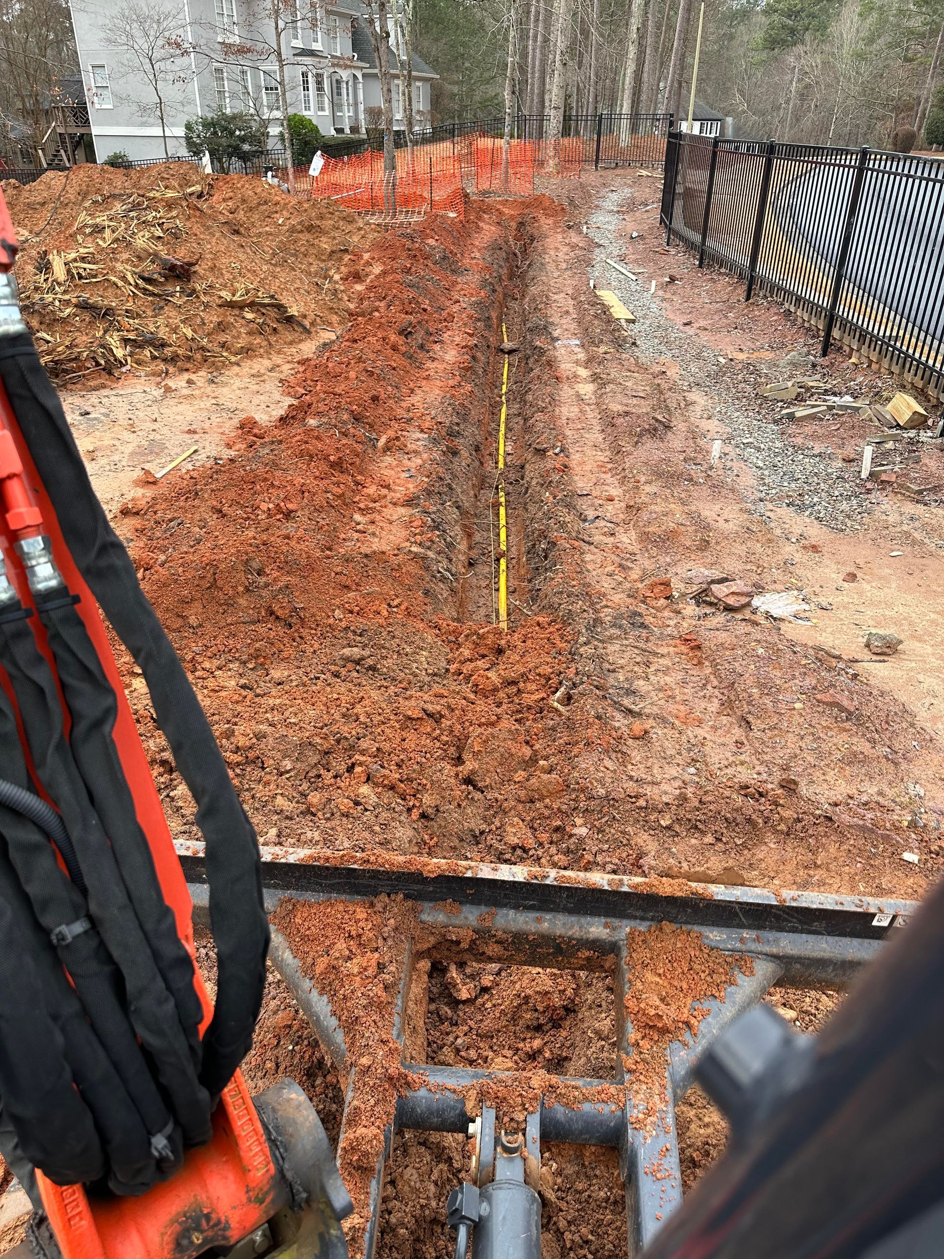 A construction vehicle is digging a trench in the dirt.