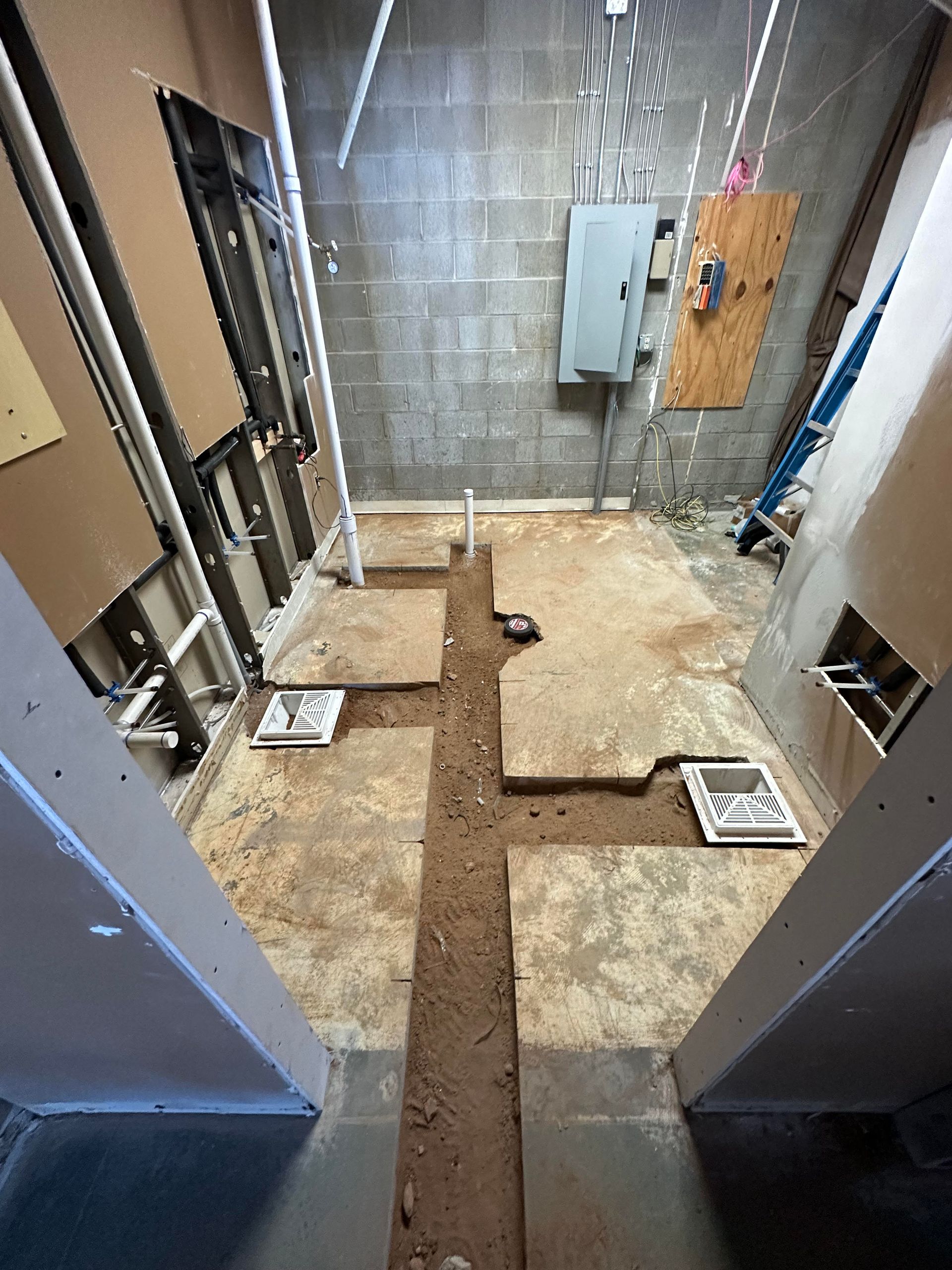 A room with a concrete floor and a brick wall.