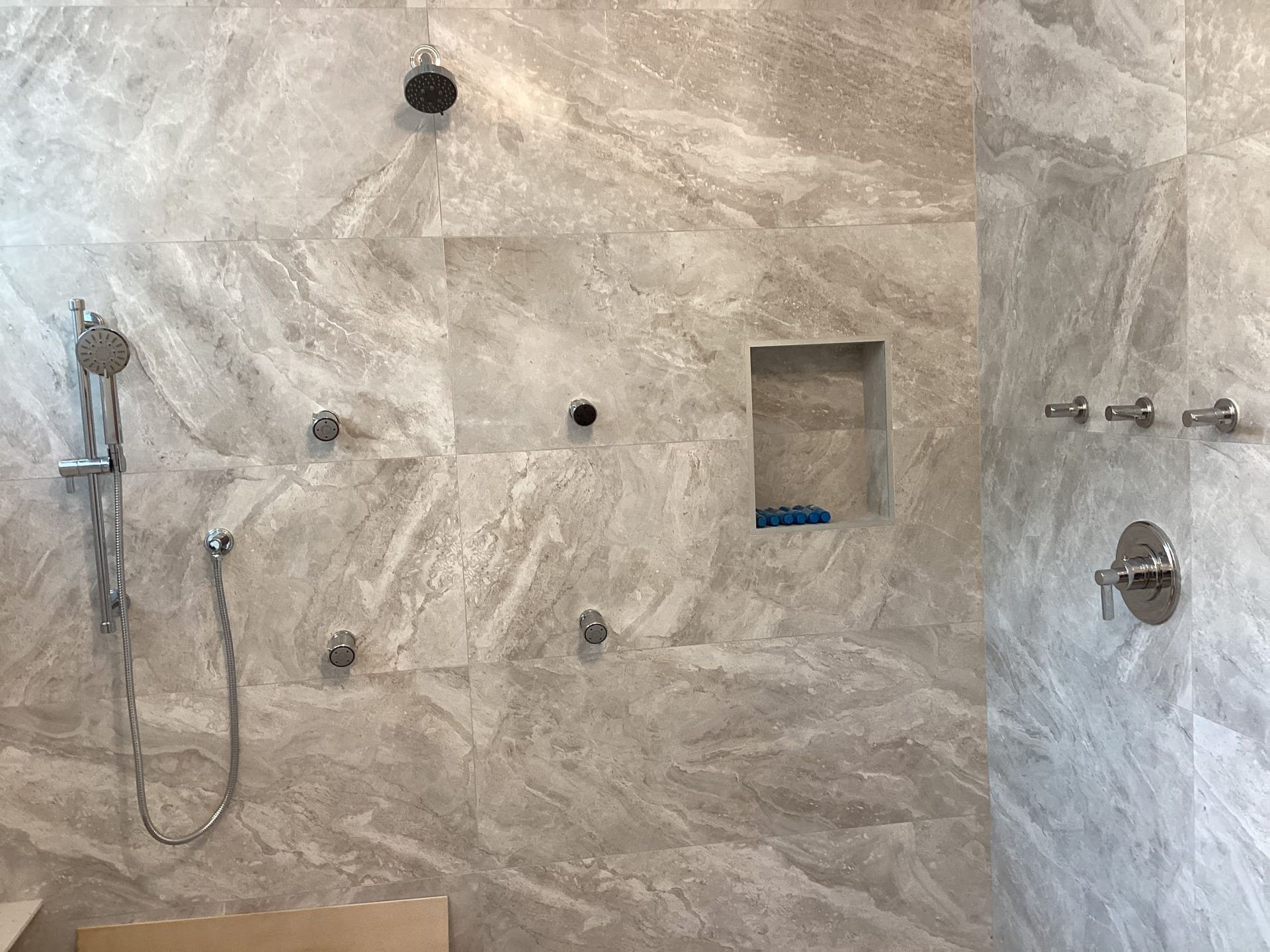 A bathroom with a walk in shower and a shower head.