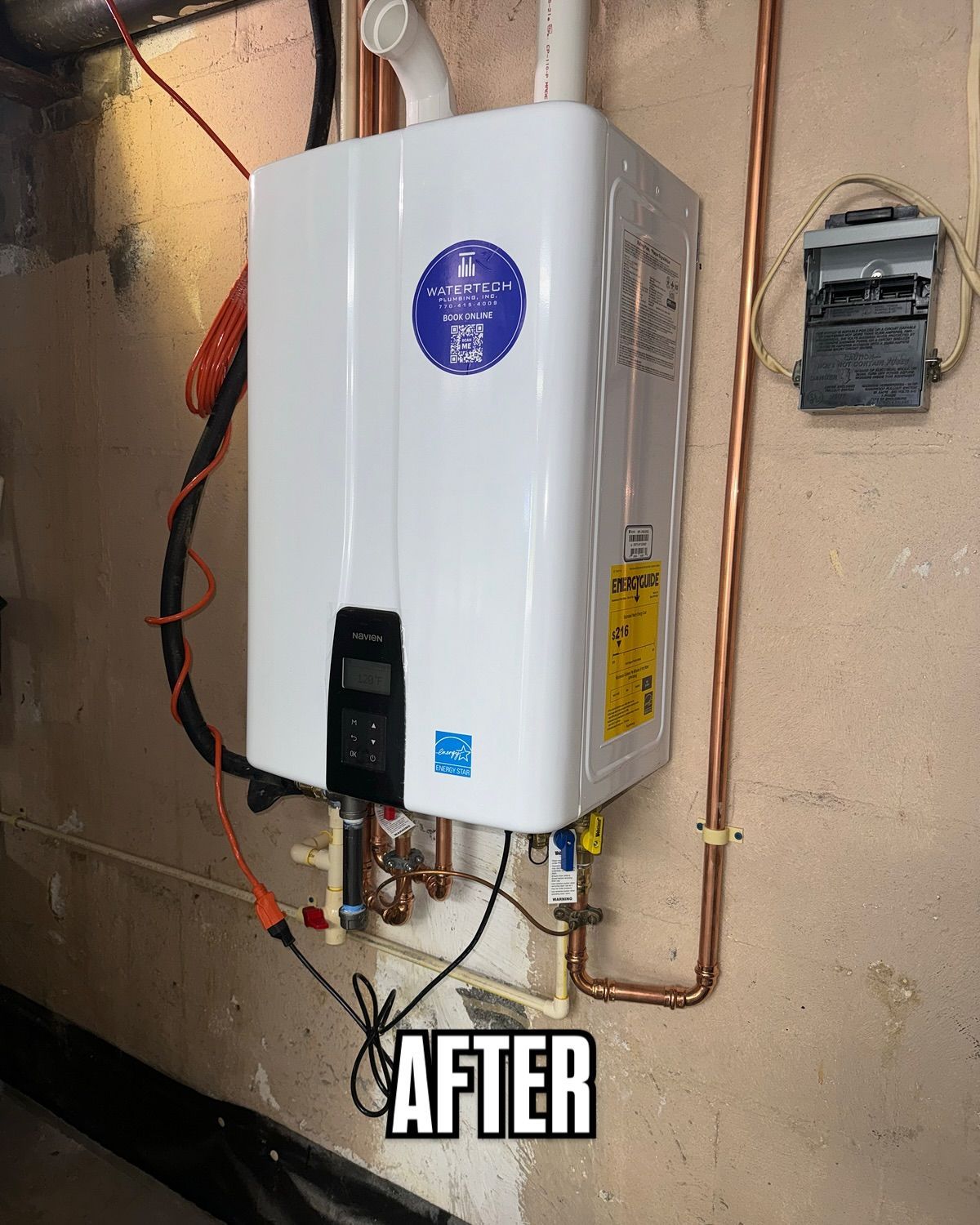 A white water heater is hanging on a wall next to copper pipes.