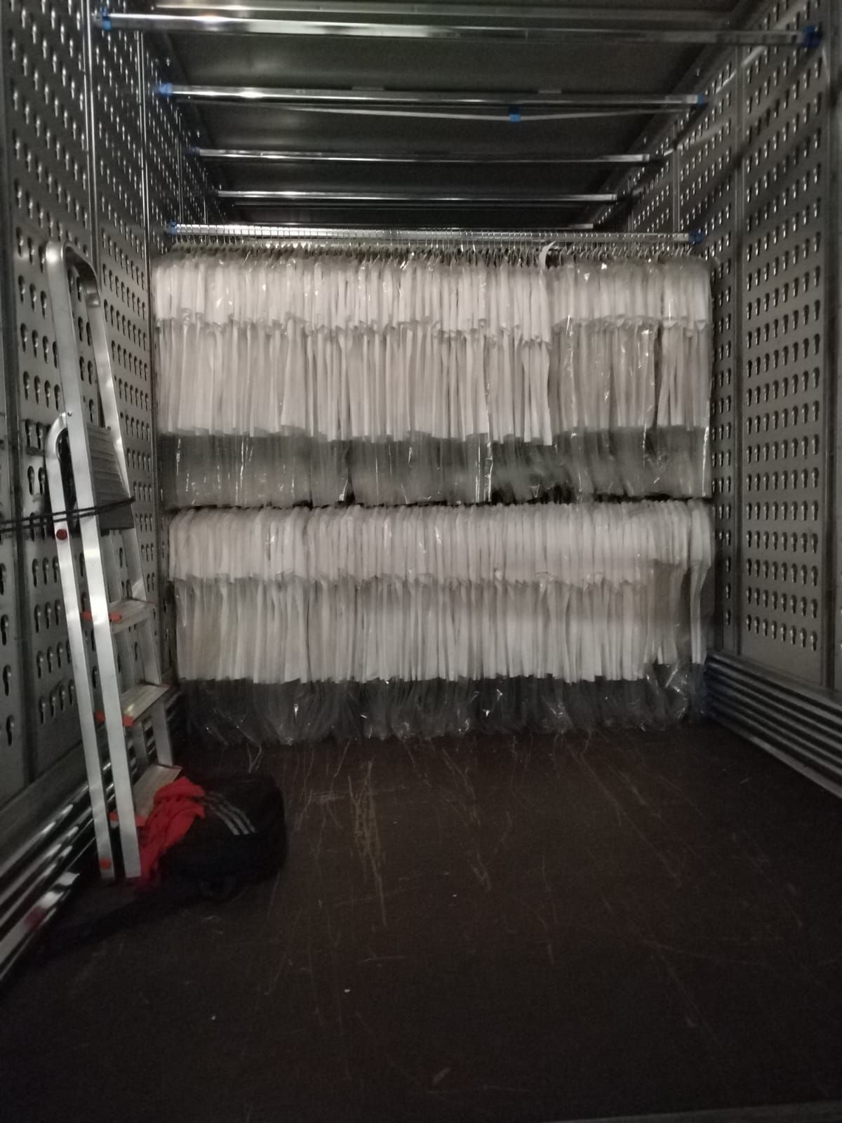 un camion pieno di vestiti in plastica e una scala