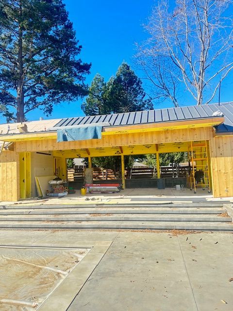 A wooden building with a metal roof is being built.