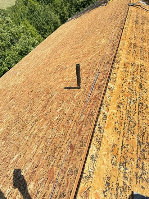 A roof with a chimney on it and a shadow of a person on it.