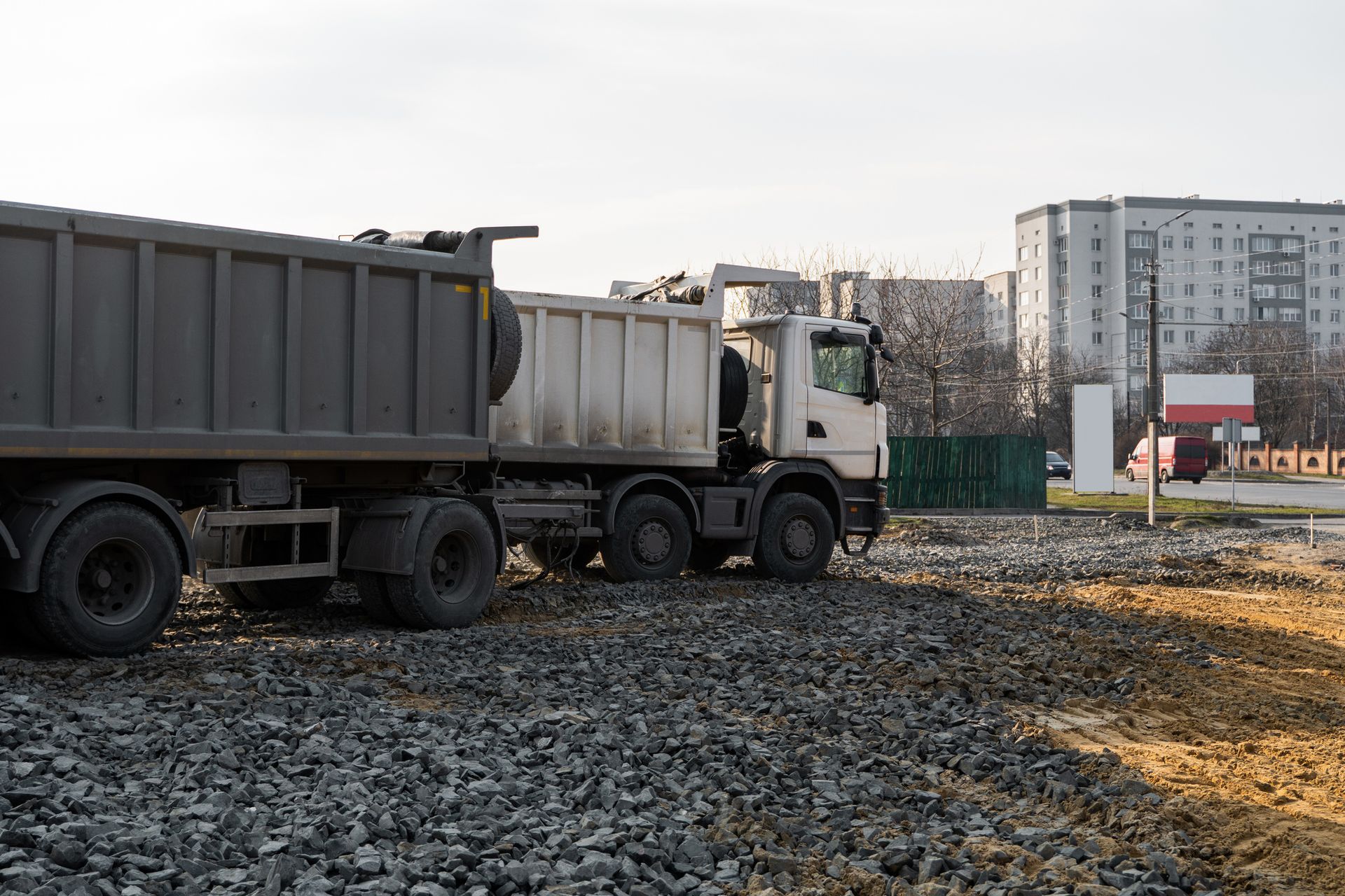 A dump truck is driving down a gravel road.