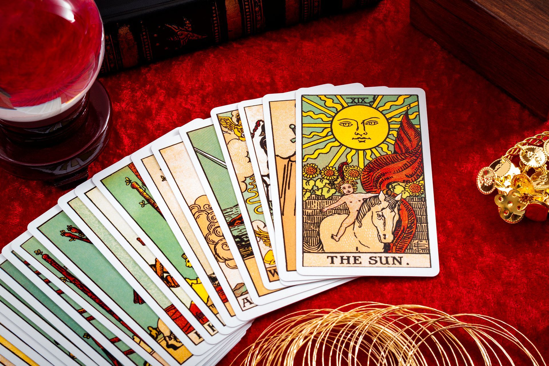 Fortune teller and whitcraft concept with tarot cards spread on red velvet surrounded.