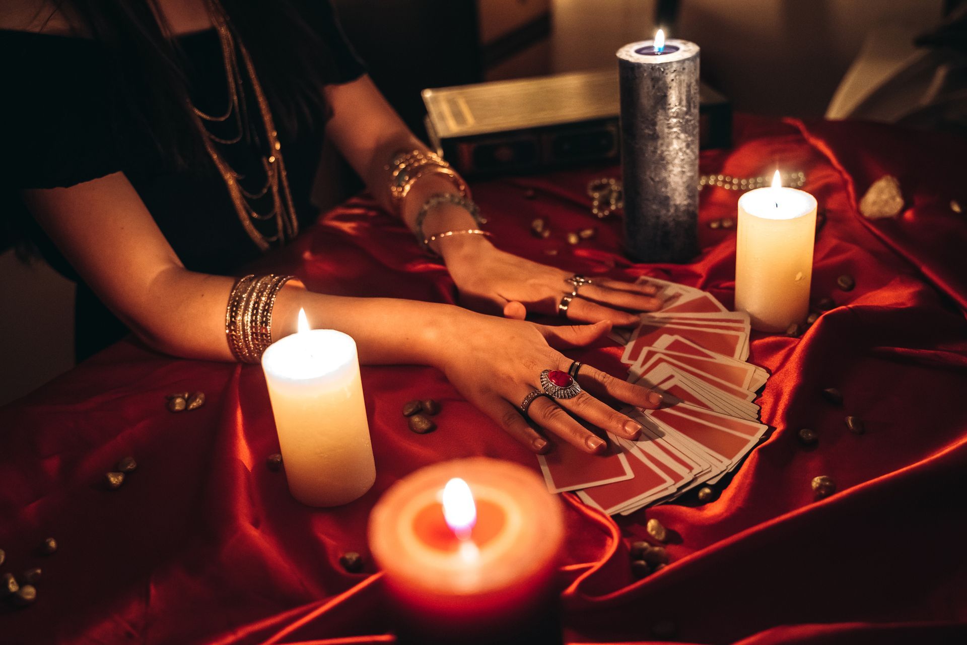 A young female fortune teller performing a psychic card reading with focused attention