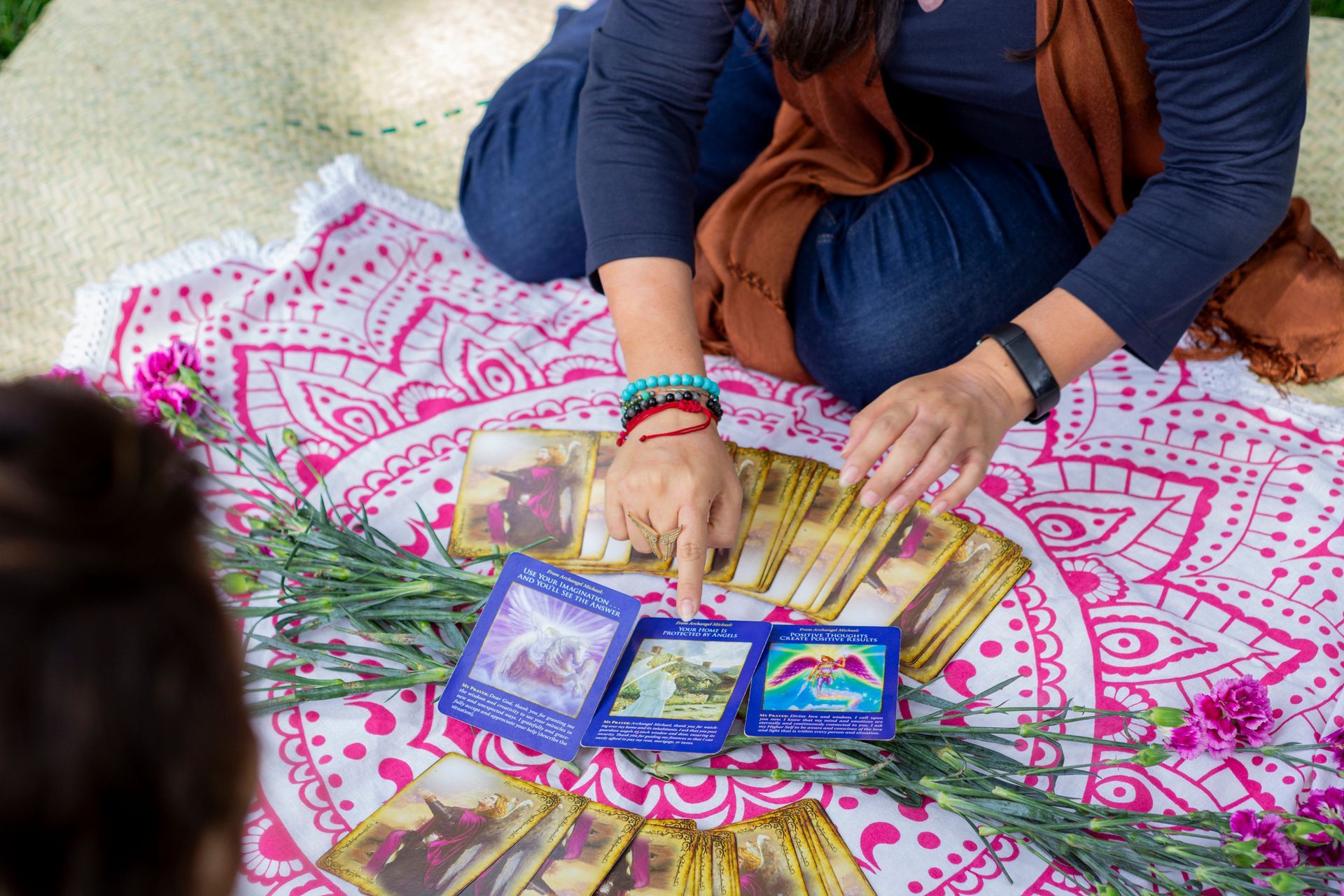 Hands of a woman pointing at a tarot card while reading a fortune to another woman Hands of a woman pointing at a tarot card while reading a fortune to another woman