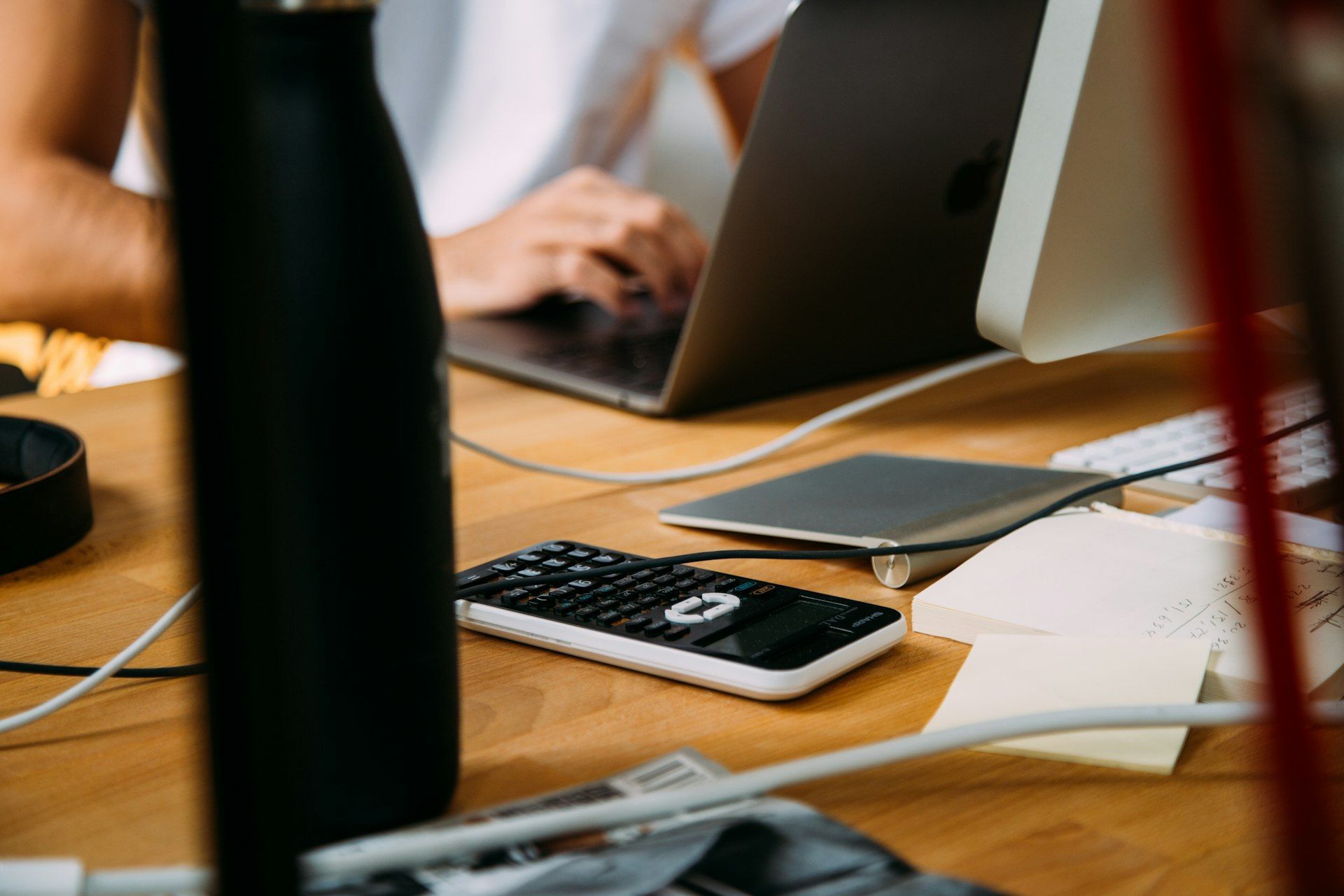 A person is sitting at a desk using a laptop computer.