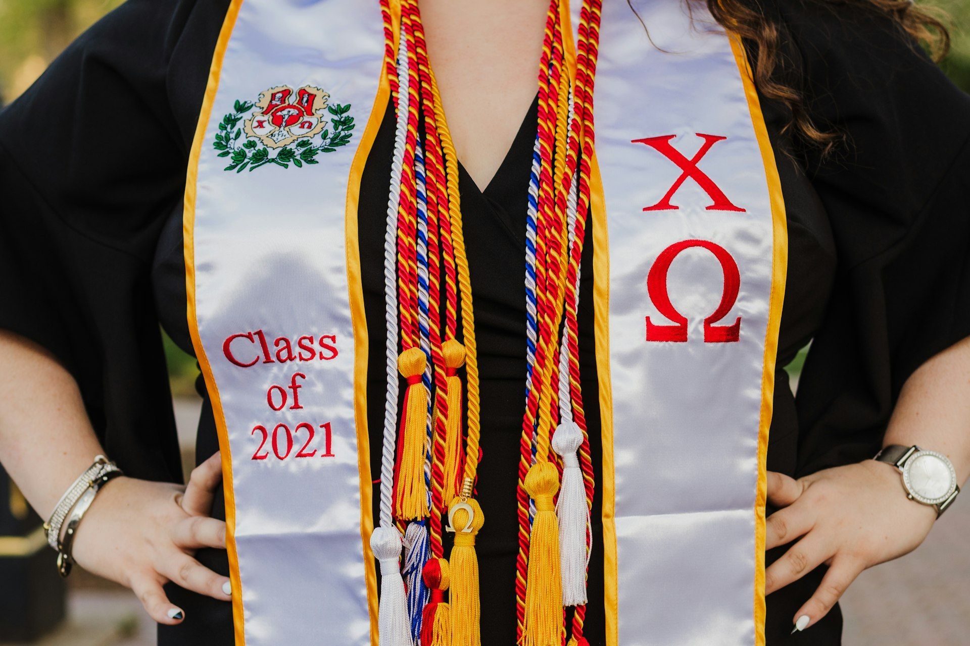A woman is wearing a white sash that says class of 2021