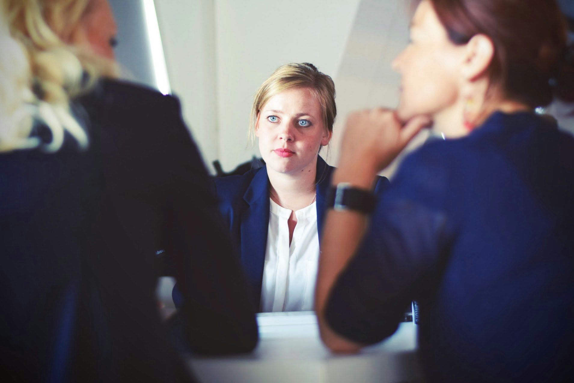 A group of women are sitting at a table having a conversation.