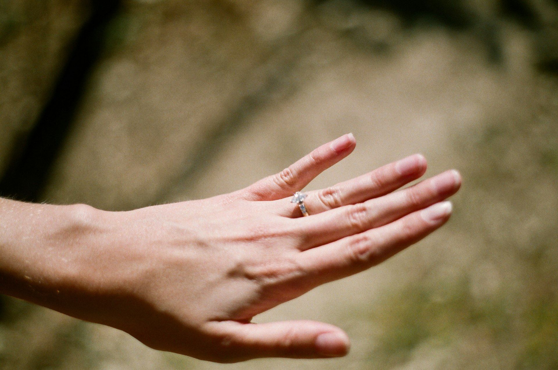 A close up of a woman 's hand with a ring on her finger.