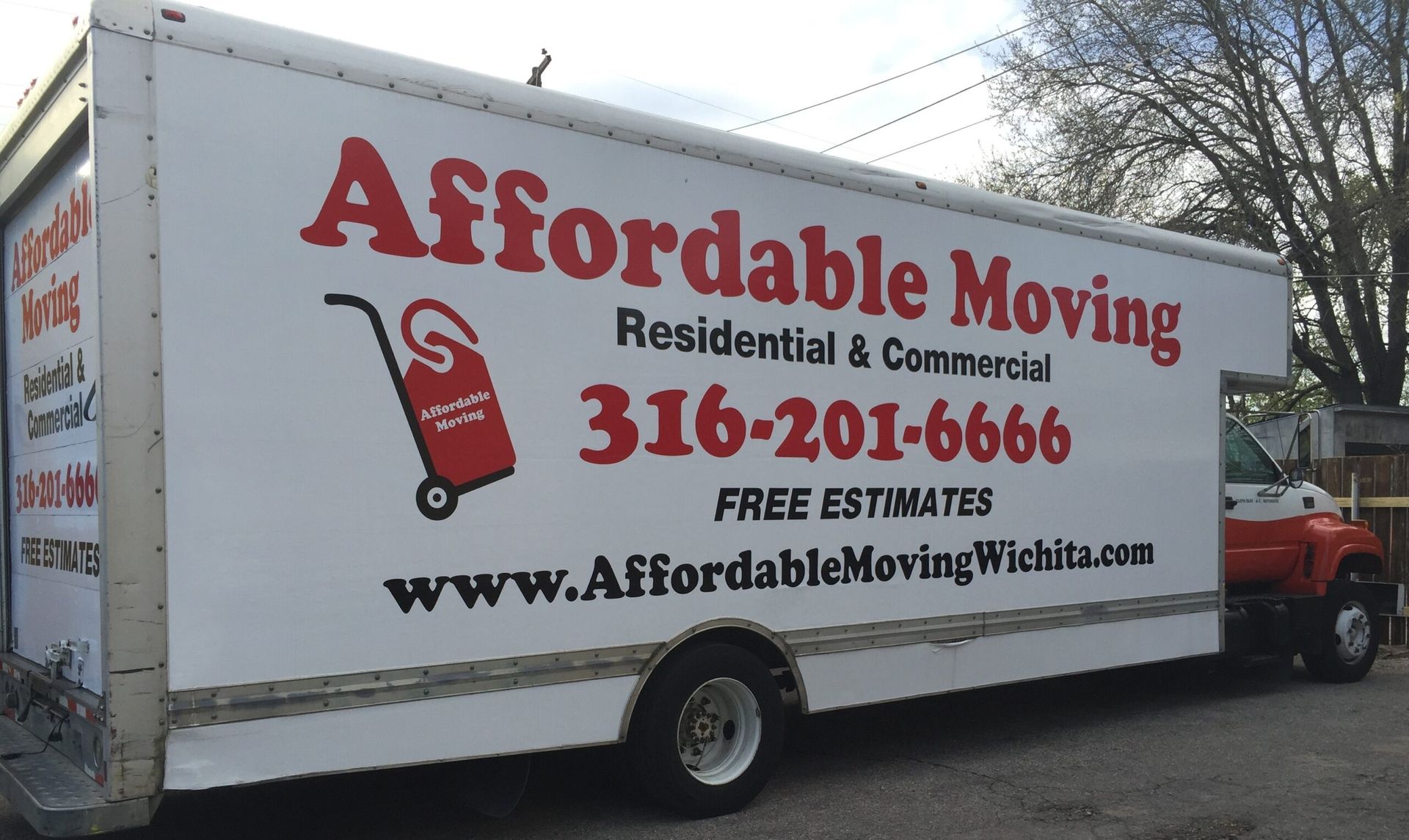 An affordable moving truck is parked on the side of the road