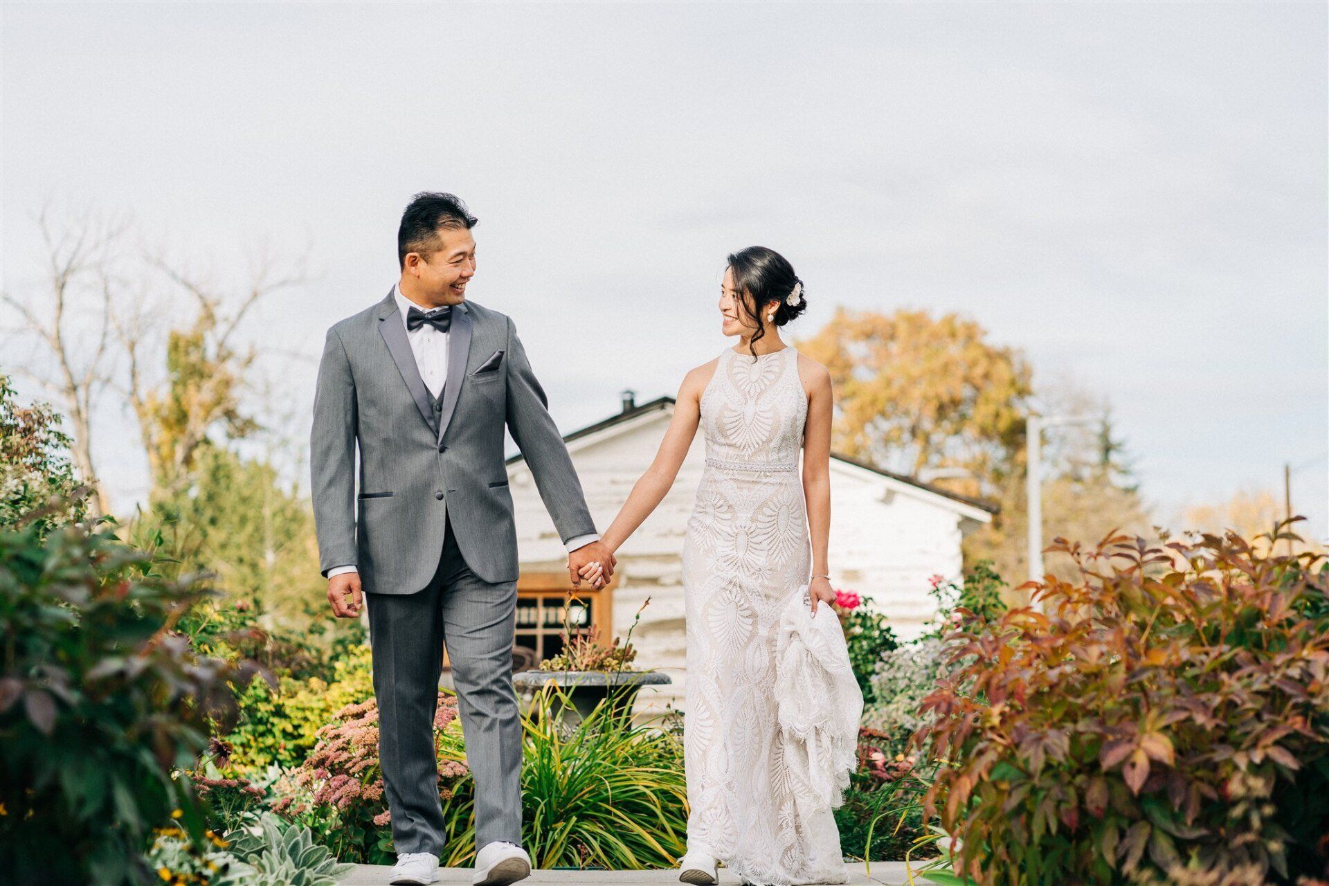 bride and groom are holding each other's hand and looking at each other while walking forward