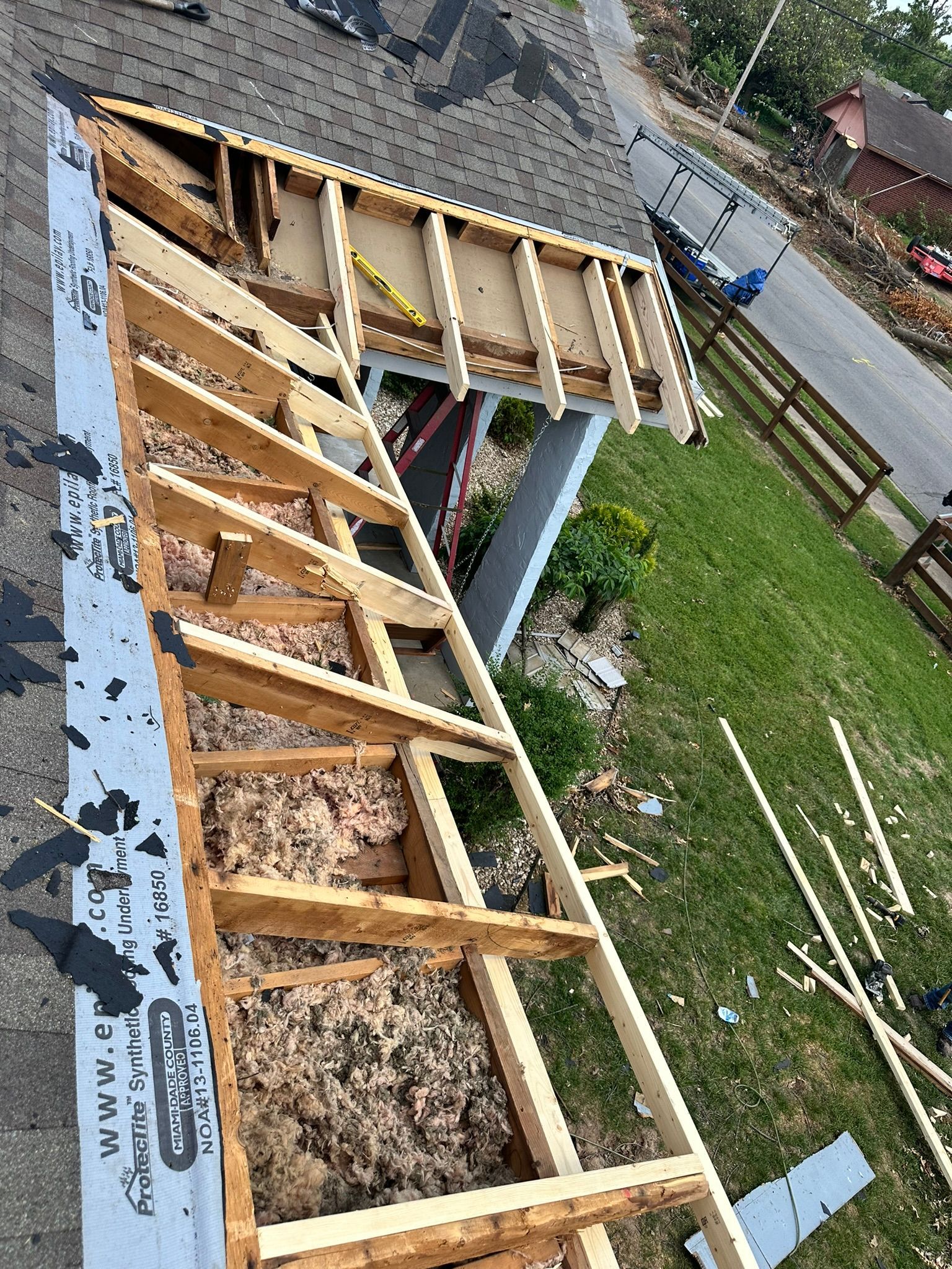 Roof of a house under construction; exposed wooden frame, insulation, and protective roofing material.