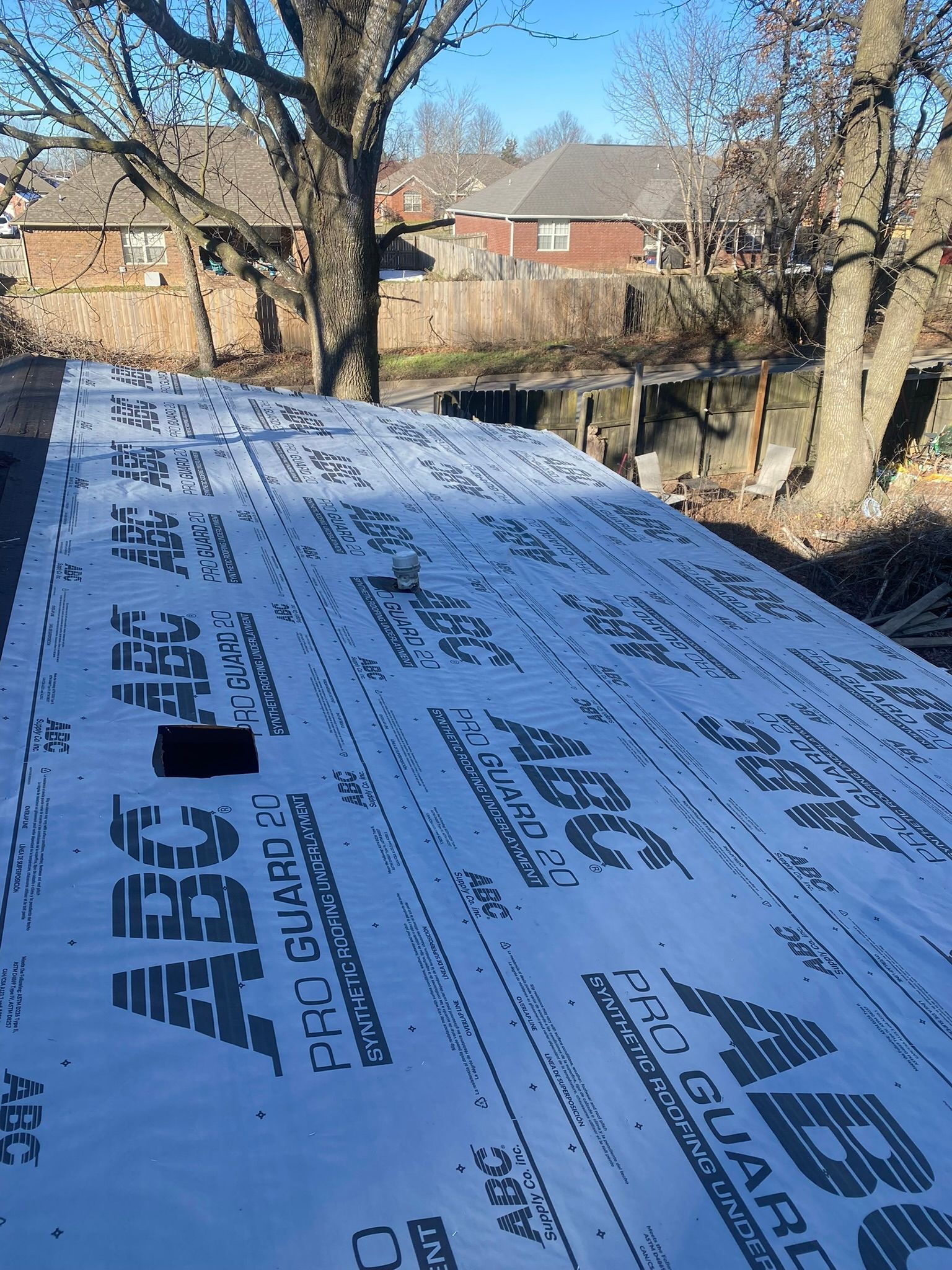 Wooden structure covered in white tarp labeled 