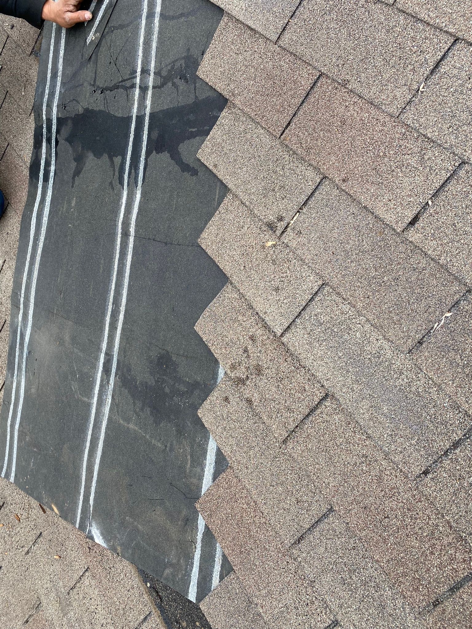 Roof shingles and underlayment being installed.