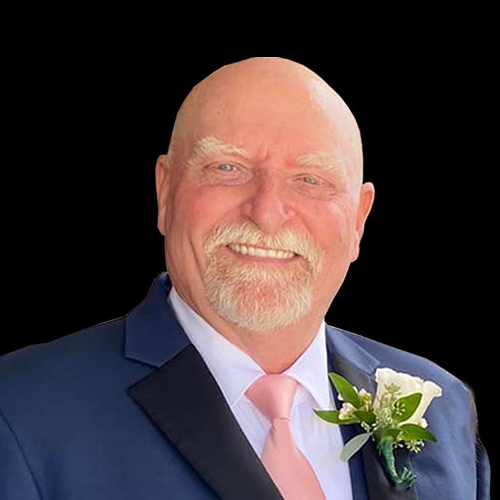 A bald man with a beard is wearing a suit and tie.