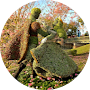 A statue of a woman standing next to a tree in a circle.
