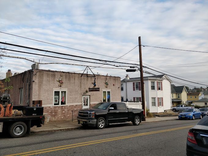 A truck is parked on the side of the road in front of a building