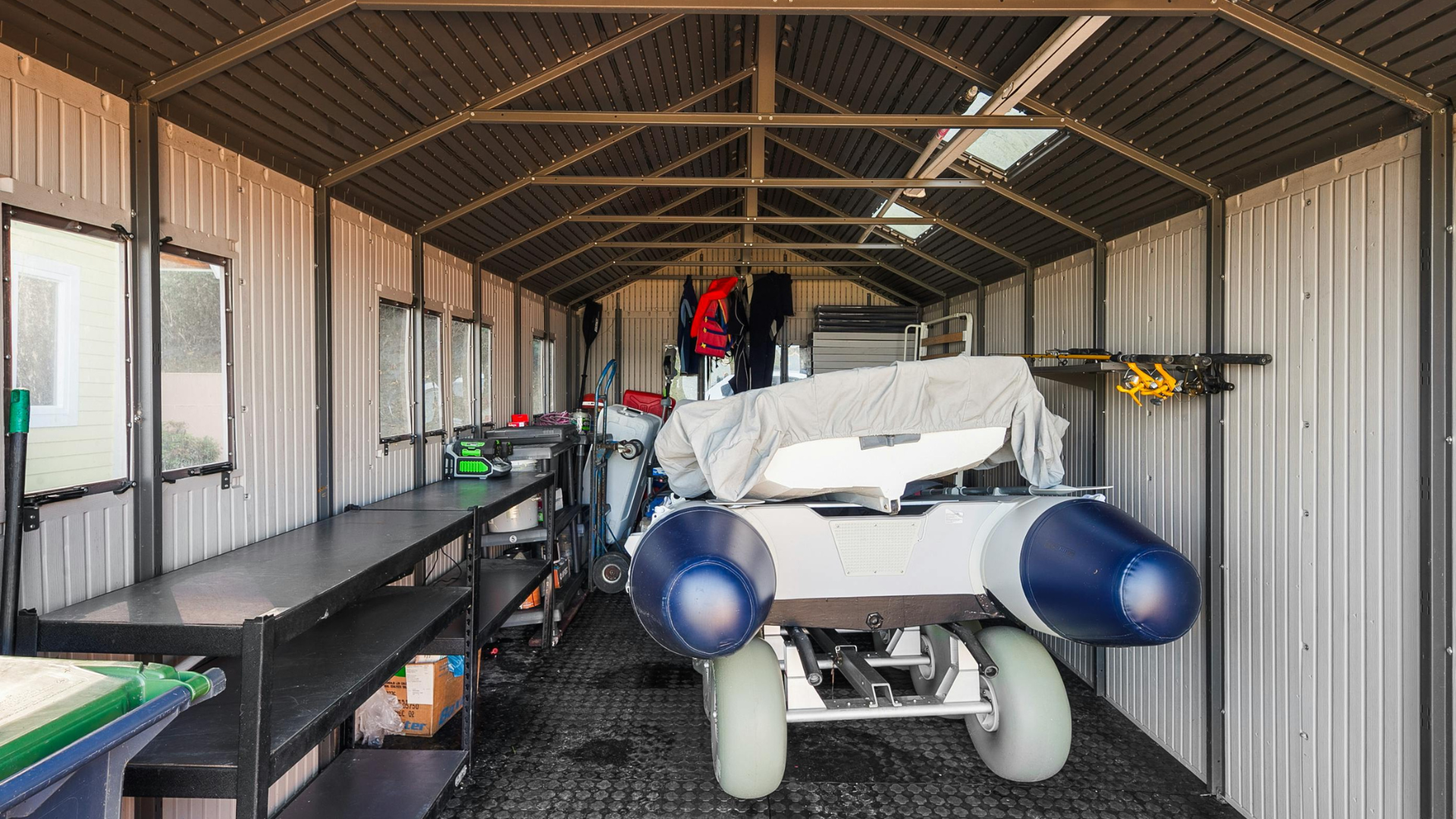 Inside a shed: motorized wheelchair, equipment, shelves, windows.