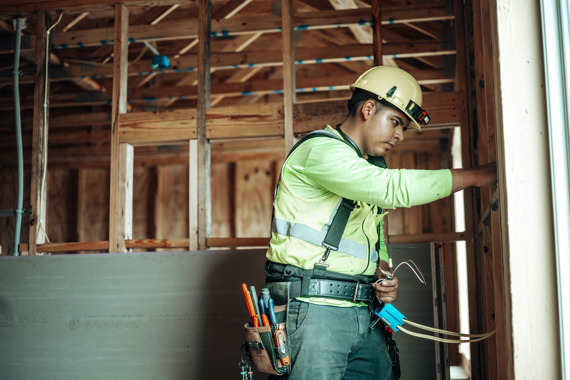 Tandem Electric electrician wiring a new construction wall in Southwest Florida