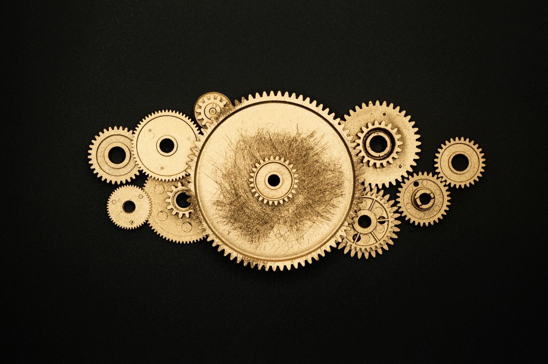 A group of gold gears on a black background.