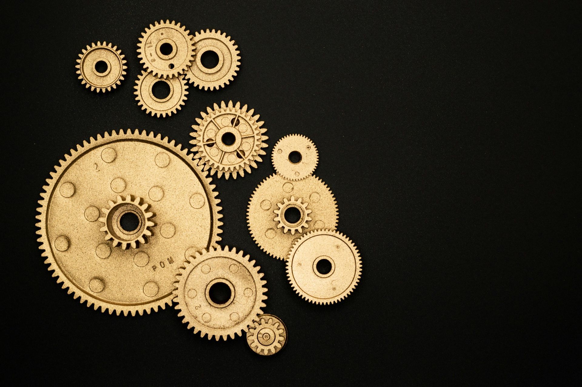 A group of gears are sitting on a black surface.