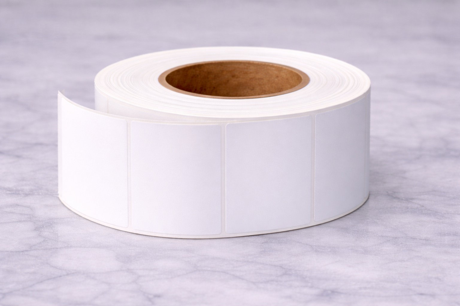 Roll of blank white rectangular labels on a light-colored surface.