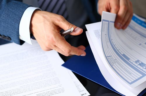 Personal Insurance — Hand Holding Papers and Pen in Gallup, NM