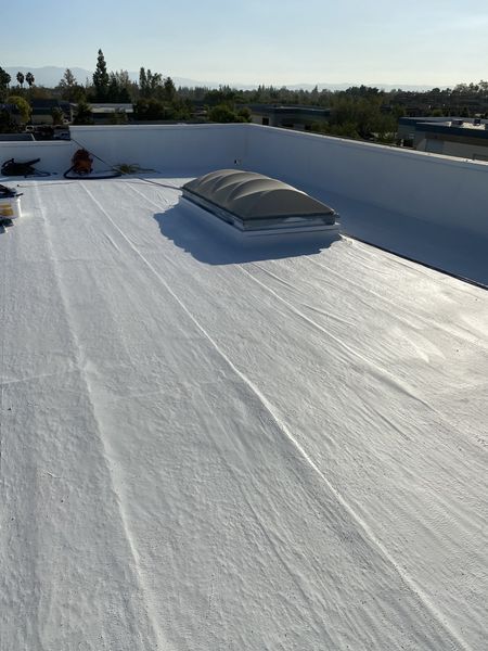 White flat rooftop with a skylight under a bright sky