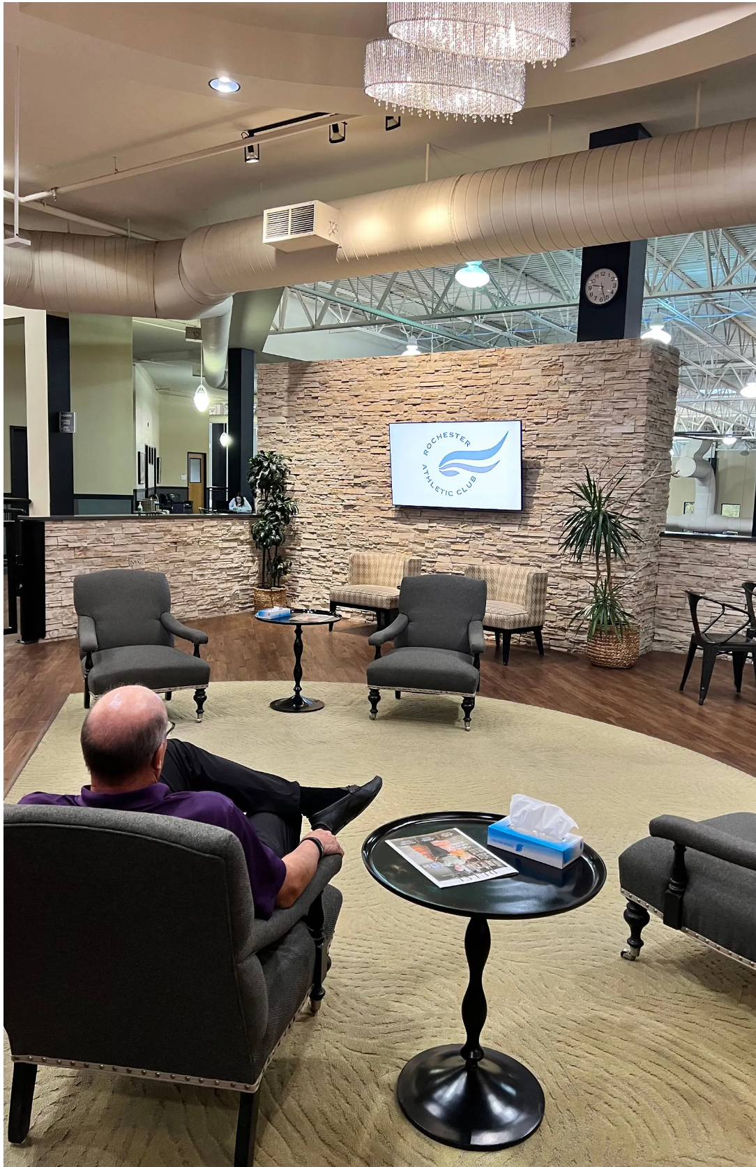 Man looking at tv screen in the Rochester Athletic Club lobby