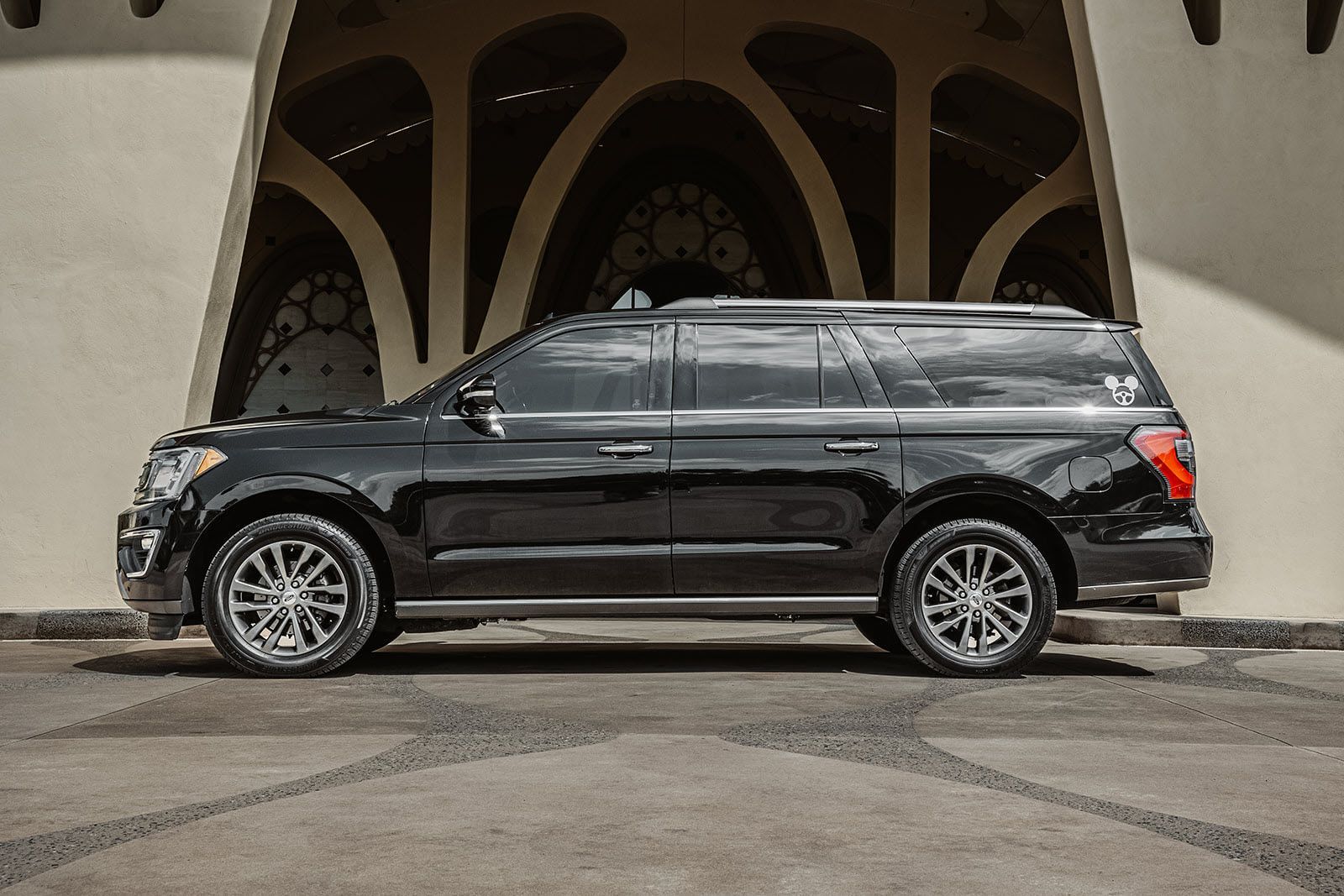 A black suv is parked in front of a building.