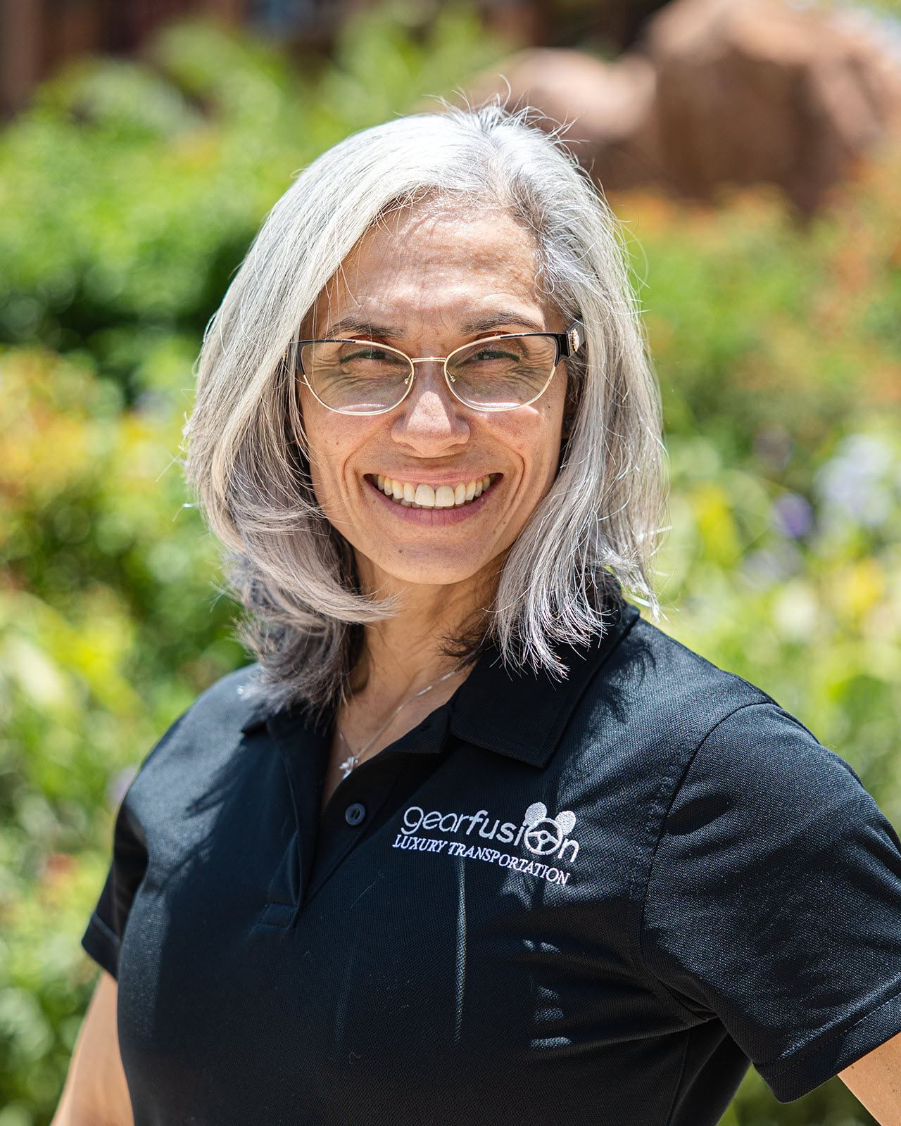 A woman wearing glasses and a black shirt is smiling for the camera.